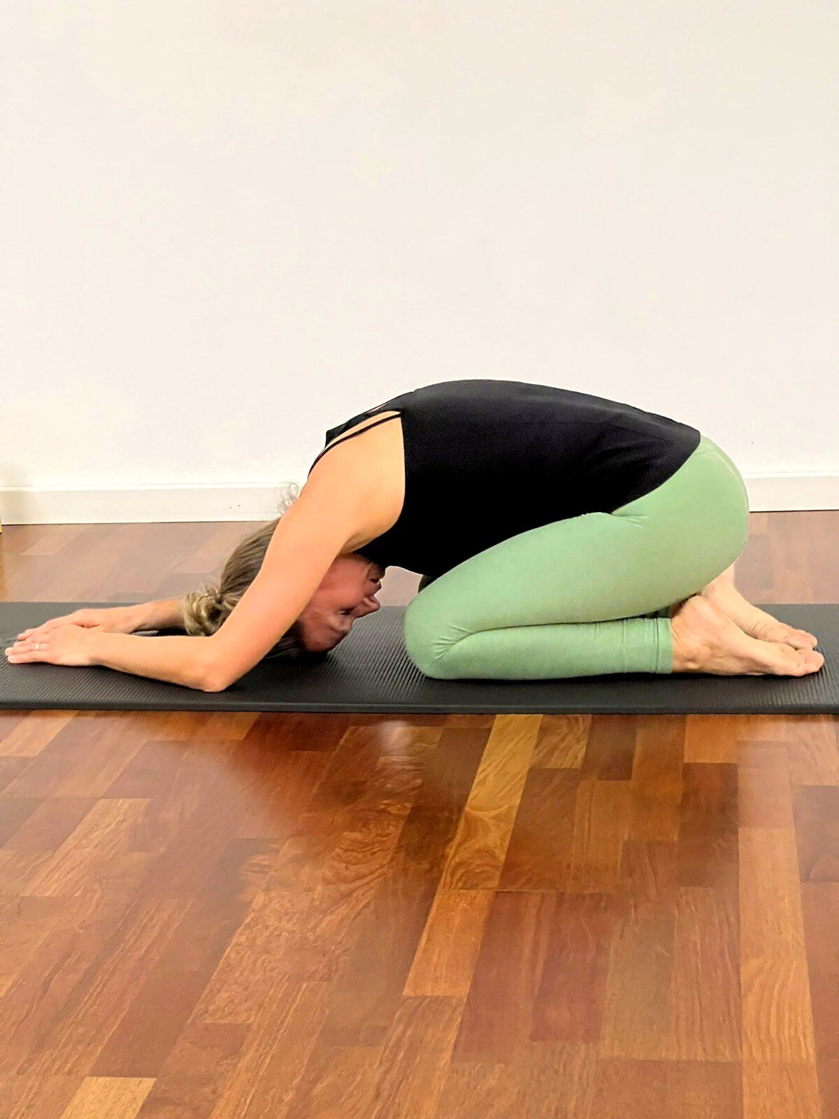 Sue Vetter in einer ruhigen Pilates-Dehnposition auf der Matte